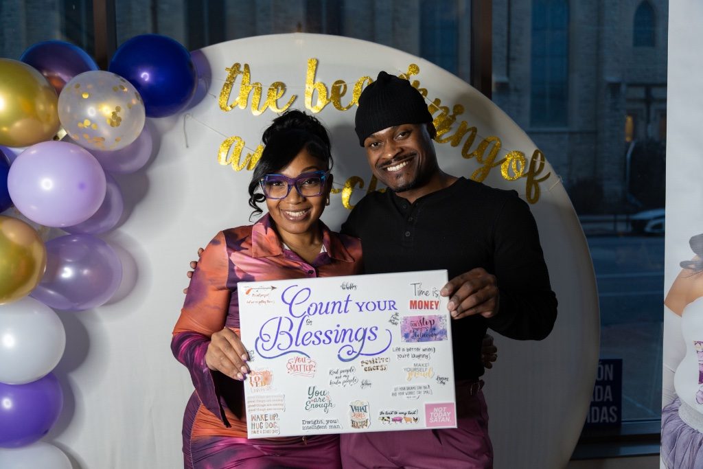 Two attendees holding a Count Your Blessings vision board