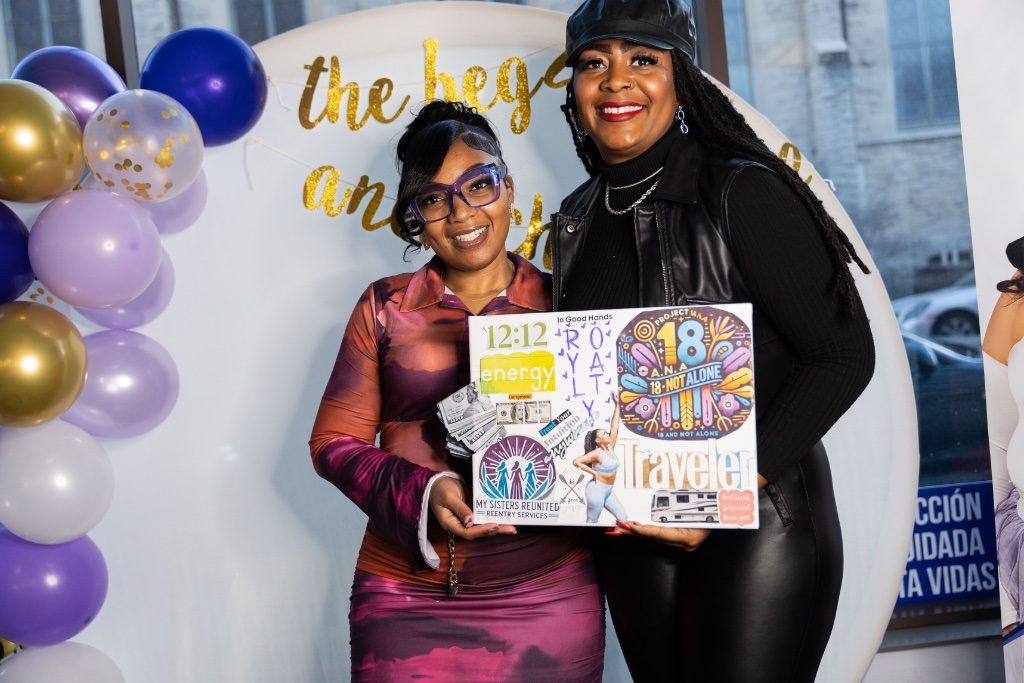 Two attendees holding a completed vision board at a workshop