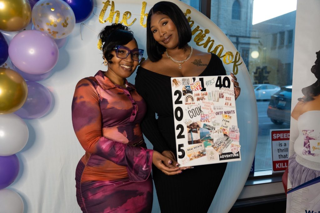 Two attendees holding a 2025 vision board